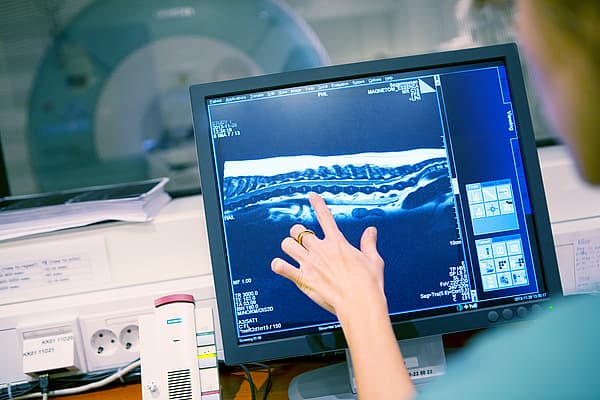 Osoba wskazująca na ekran komputera.